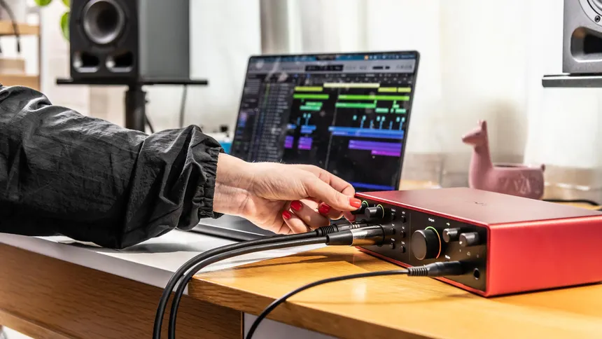 Photo of a multi-channel audio interface with many input and output jacks, demonstrating the connections required for a hybrid studio setup