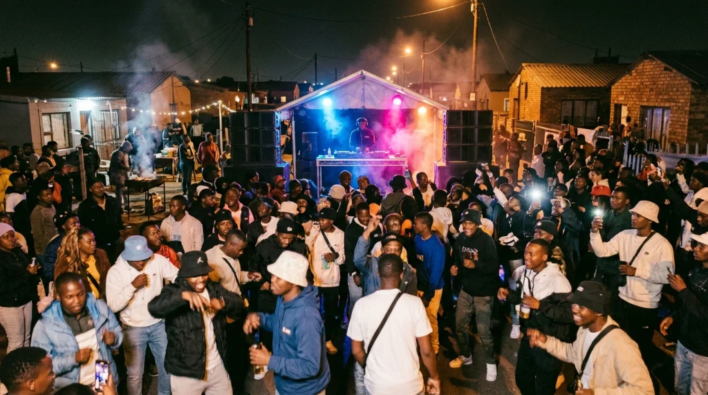 Crowd dancing to amapiano at an outdoor township party in South Africa